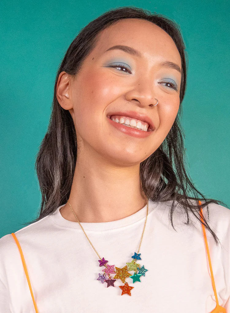 Smiling woman wearing the rainbow star necklace