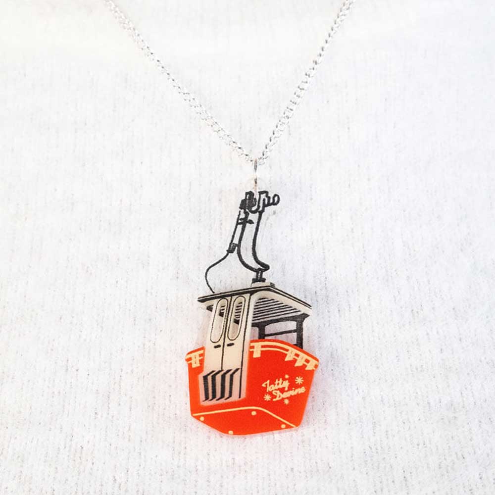 Close-up of the cable car pendant on a white jumper