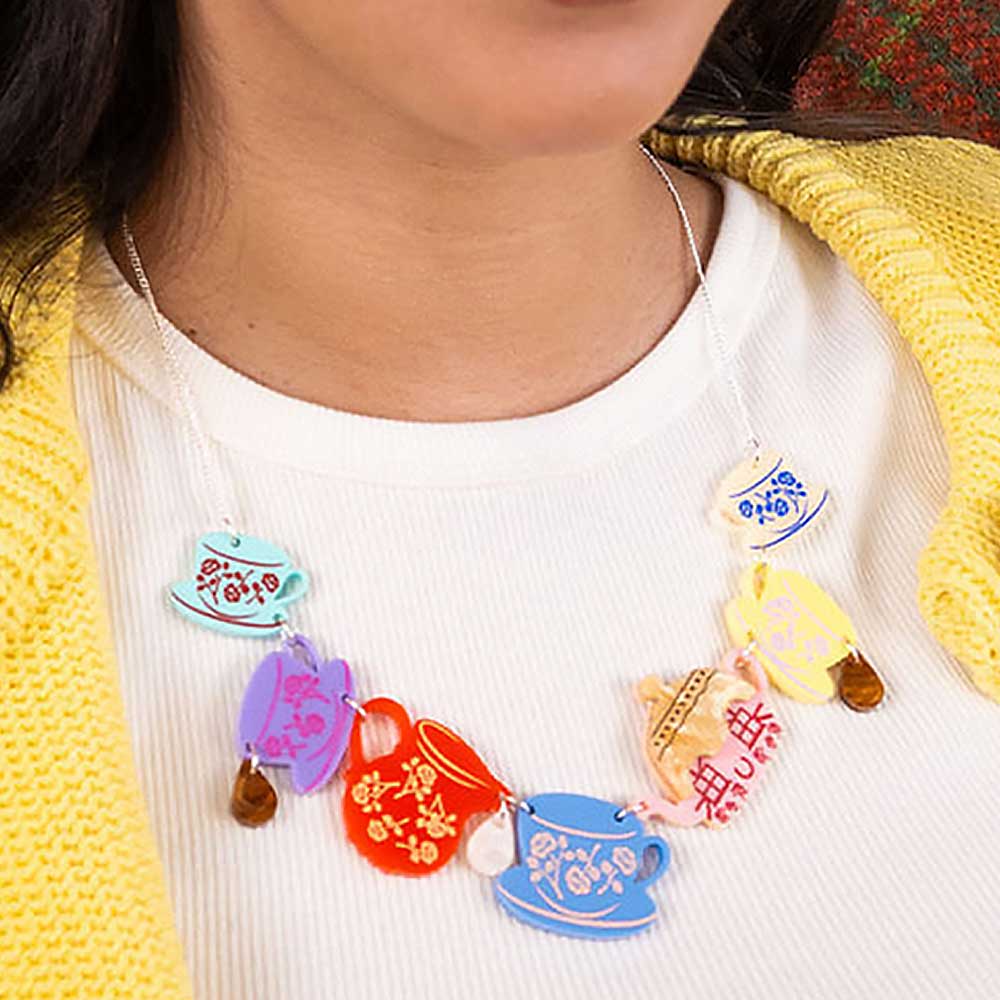 Cottage tea set necklace worn with a yellow cardigan