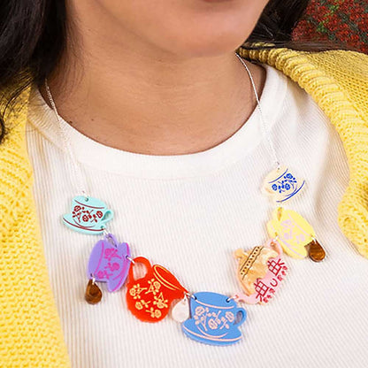 Cottage tea set necklace worn with a yellow cardigan