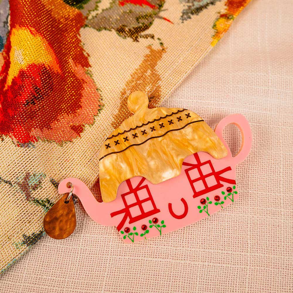 Cottage teapot brooch on embroidered fabric