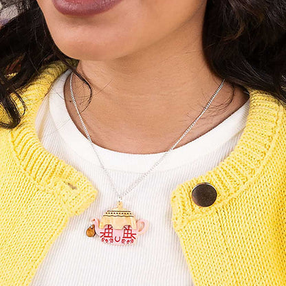 Cottage teapot pendant worn with a yellow cardigan