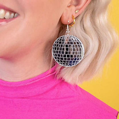 Woman with blonde hair wearing a disco ball earring