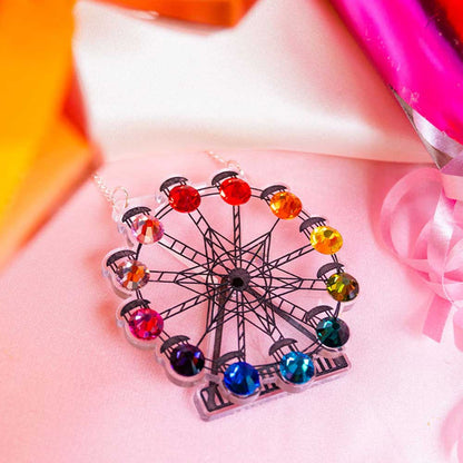 Ferris wheel necklace against pink balloons and ribbon