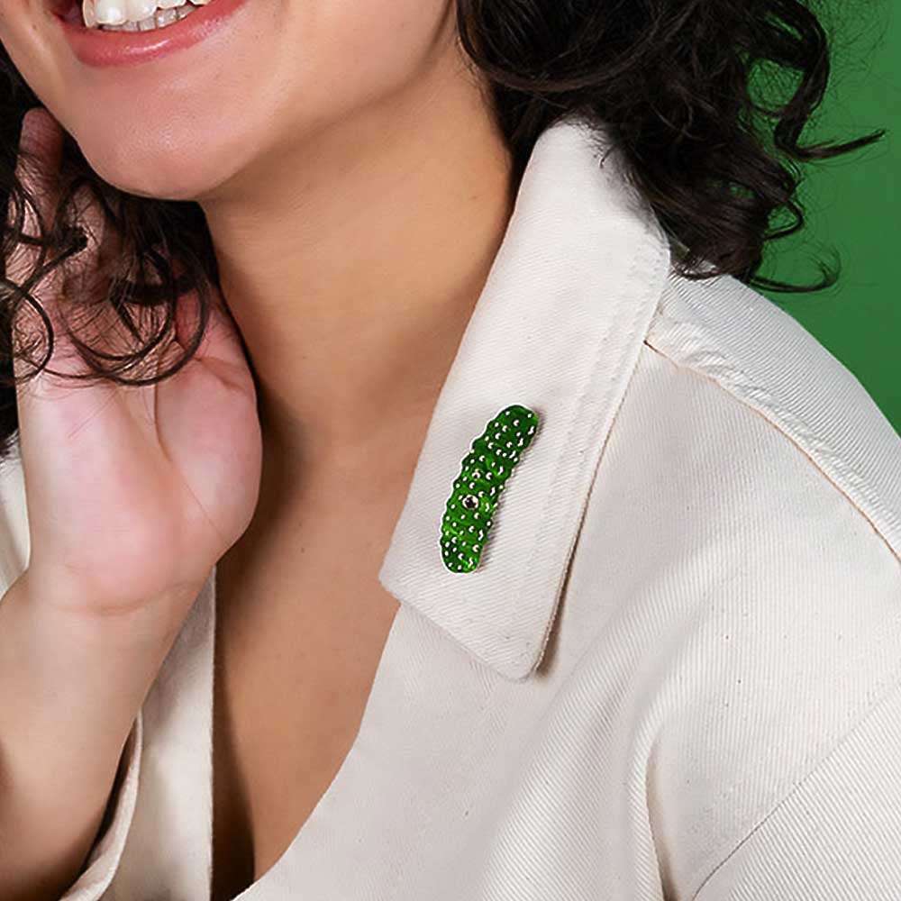 Woman wearing the pickle brooch on a cream collar