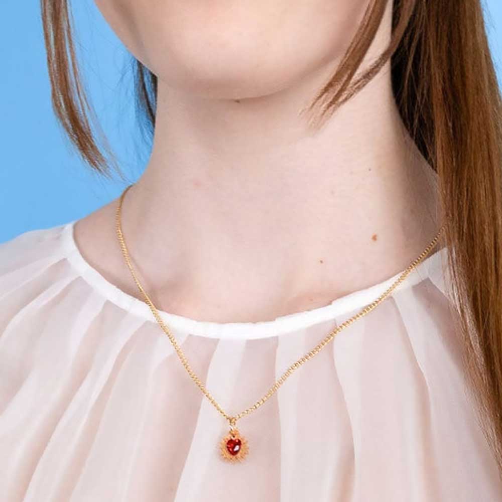 Mini immaculate heart pendant worn with a sheer white blouse