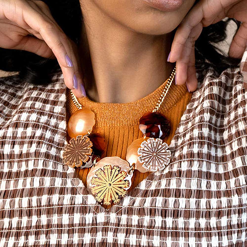 Woman adjusting the seed pods necklace