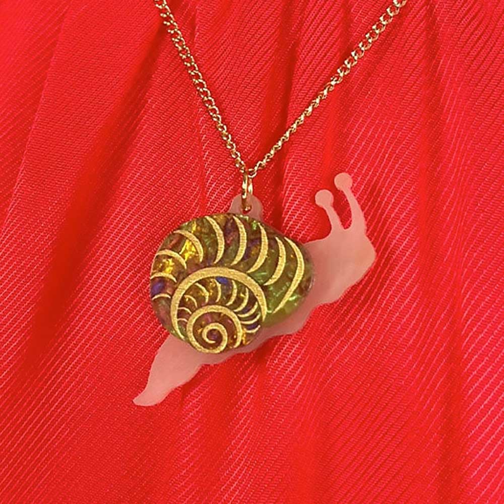 Snail pendant against a red top