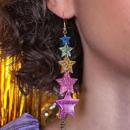 Super Star earrings worn against a gold backdrop