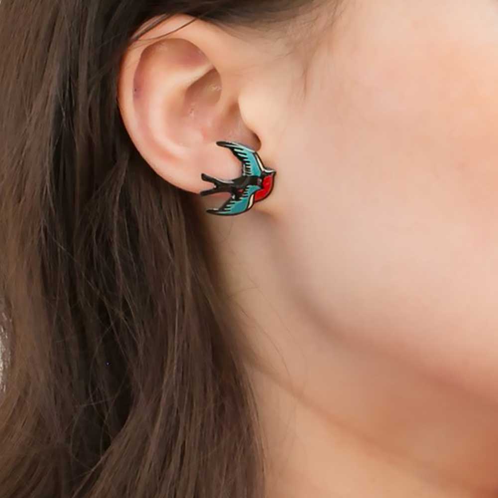 Swallow earring worn on an ear