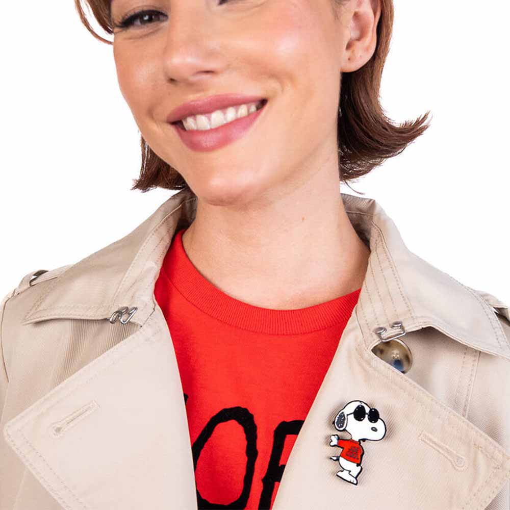 Smiling woman wearing the Joe Cool brooch on a trench coat