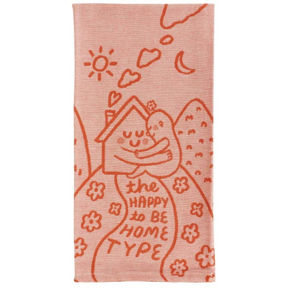 Blue Q tea towel, folded: orange line drawings of a smiling house and hills, with 'The happy to be home type'