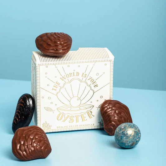 The World Is Your Oyster praline-filled chocolate seashells beside their box