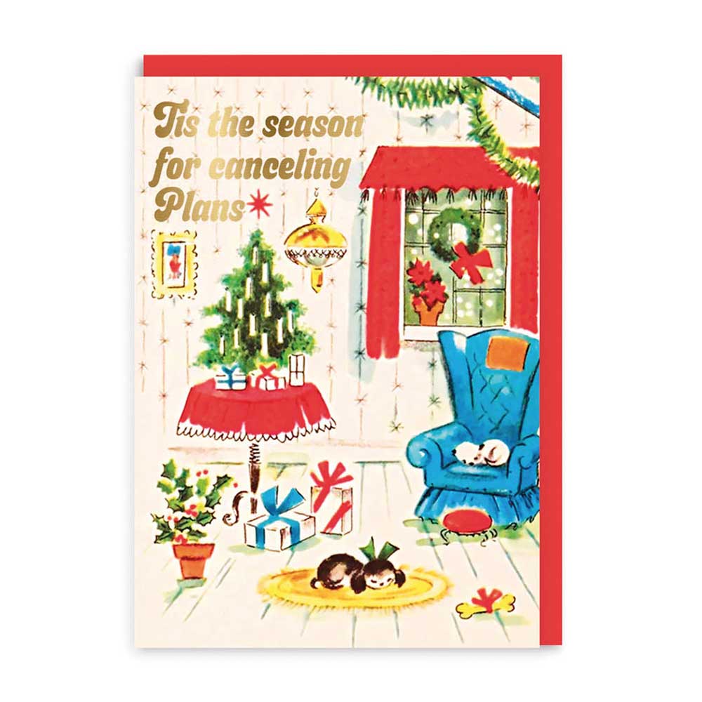 Ohh Deer Christmas card: a cosy room with a tree and armchair, with gold 'Tis the season for cancelling plans'