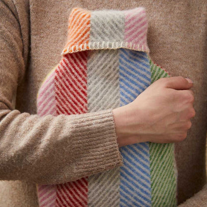 Person hugging the striped wool hot water bottle