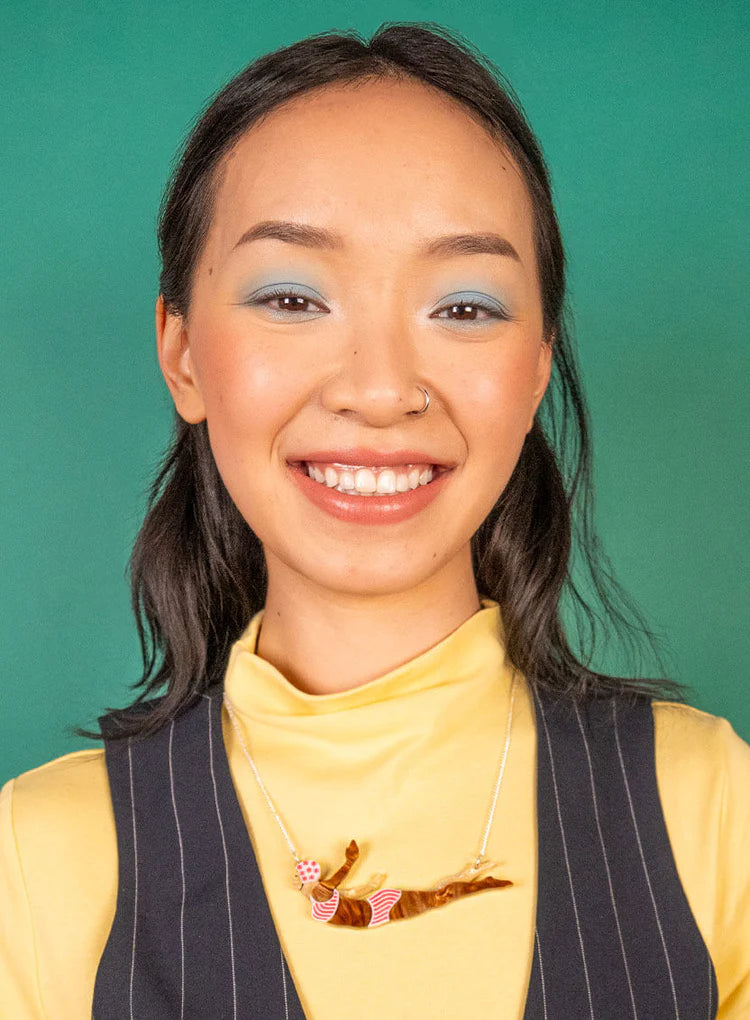 Smiling woman wearing the wild swimmer necklace